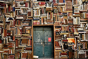 Ovi, jonka ympärillä hyllyt täynnä kirjoja.