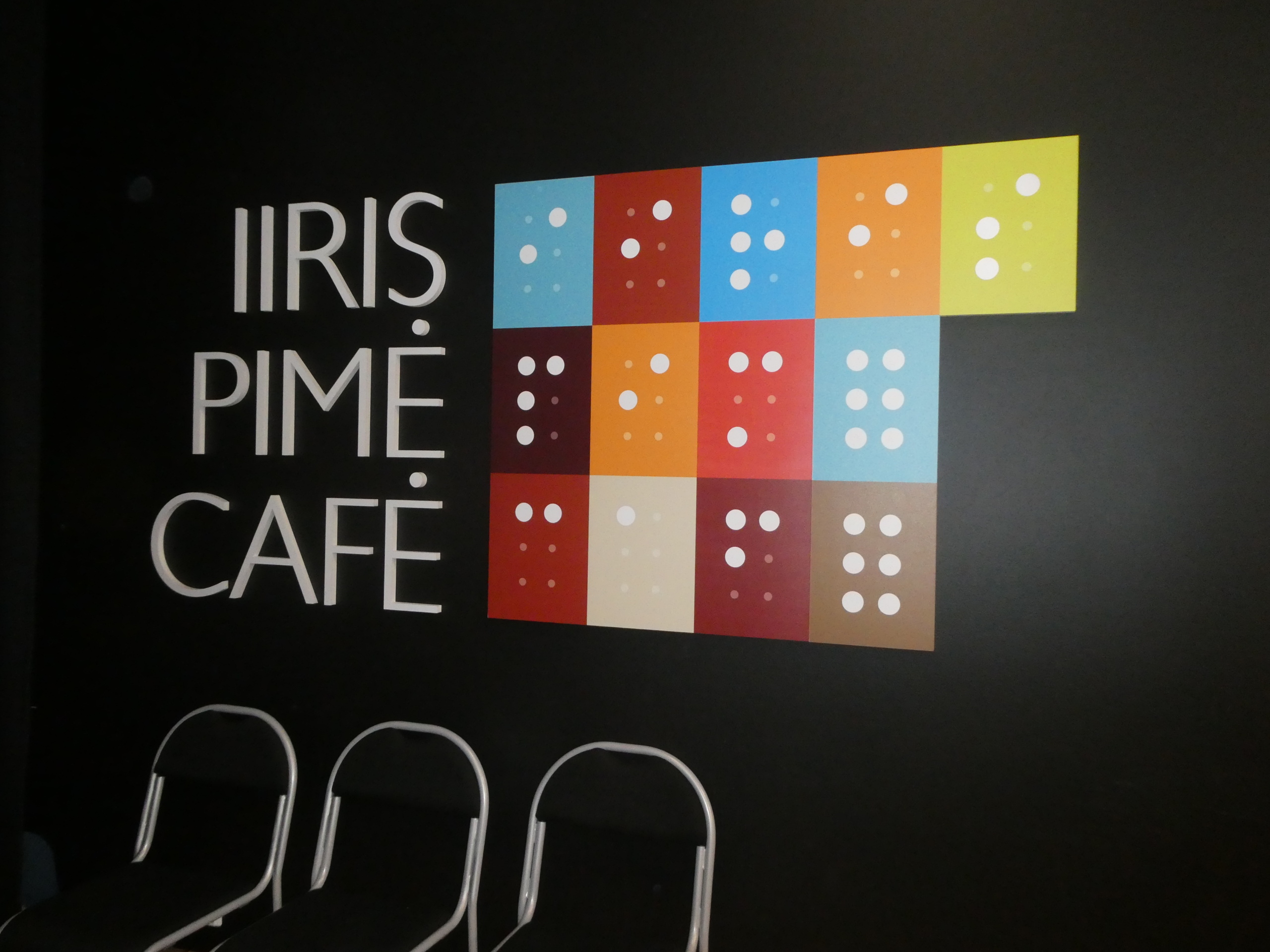 Pistekirjoituksella kirjoitettu kyltti, jossa lukee Iiris Pimé Café.