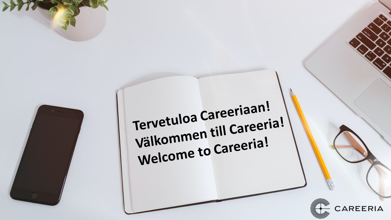 Pöydällä puhelin, kynä, silmälasit, kannettava tietokone ja muistilehtiö, jossa lukee: Tervetuloa Careeriaan! Välkommen till Careeria! Welcome to Careeria!