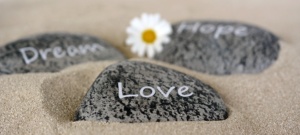 Kolme kiveä hiekalla, joissa lukee dream, hope, love.