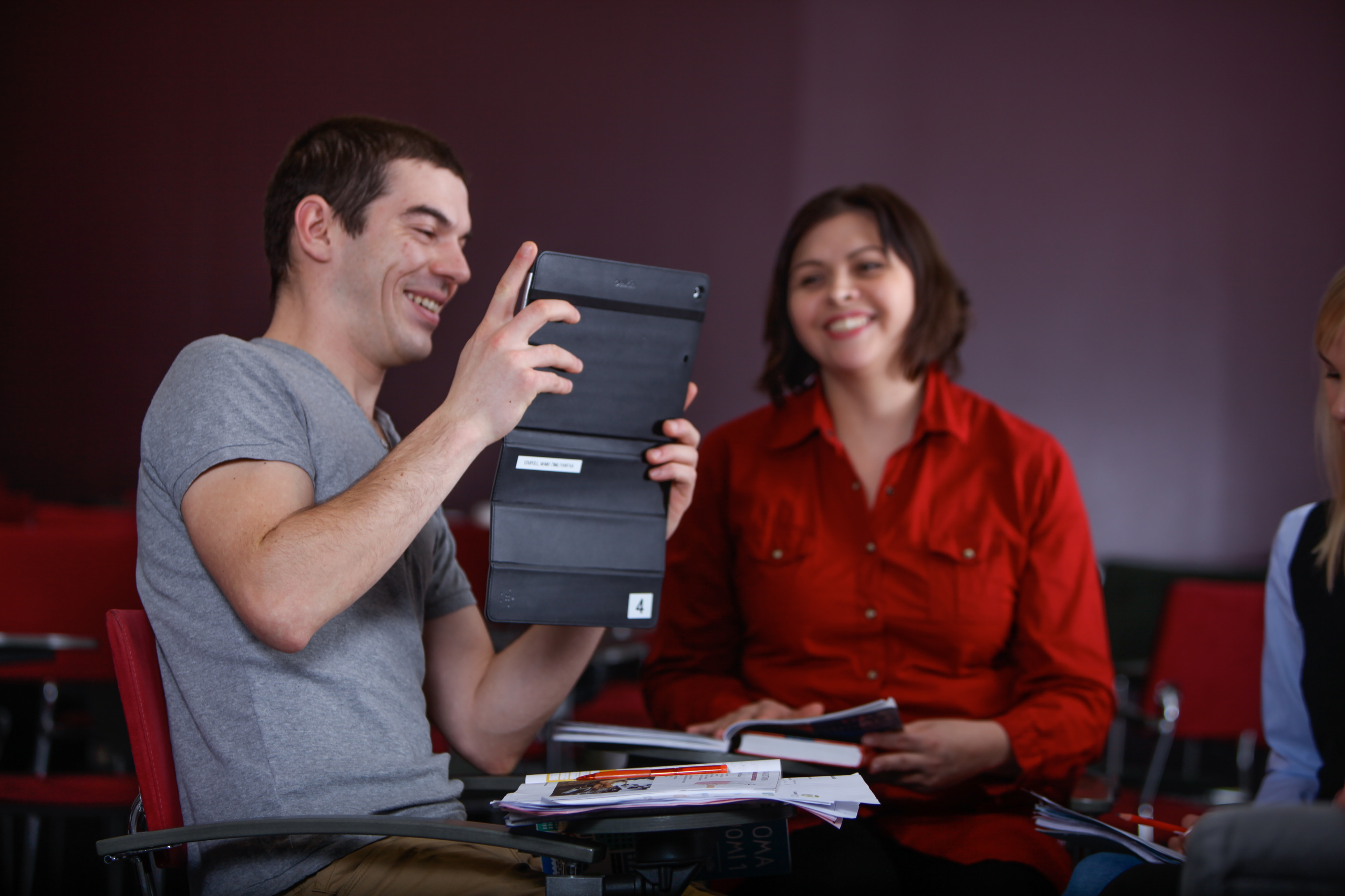 Mies ja nainen katselevat hymyillen yhdessä kannettavaa tietokonetta.