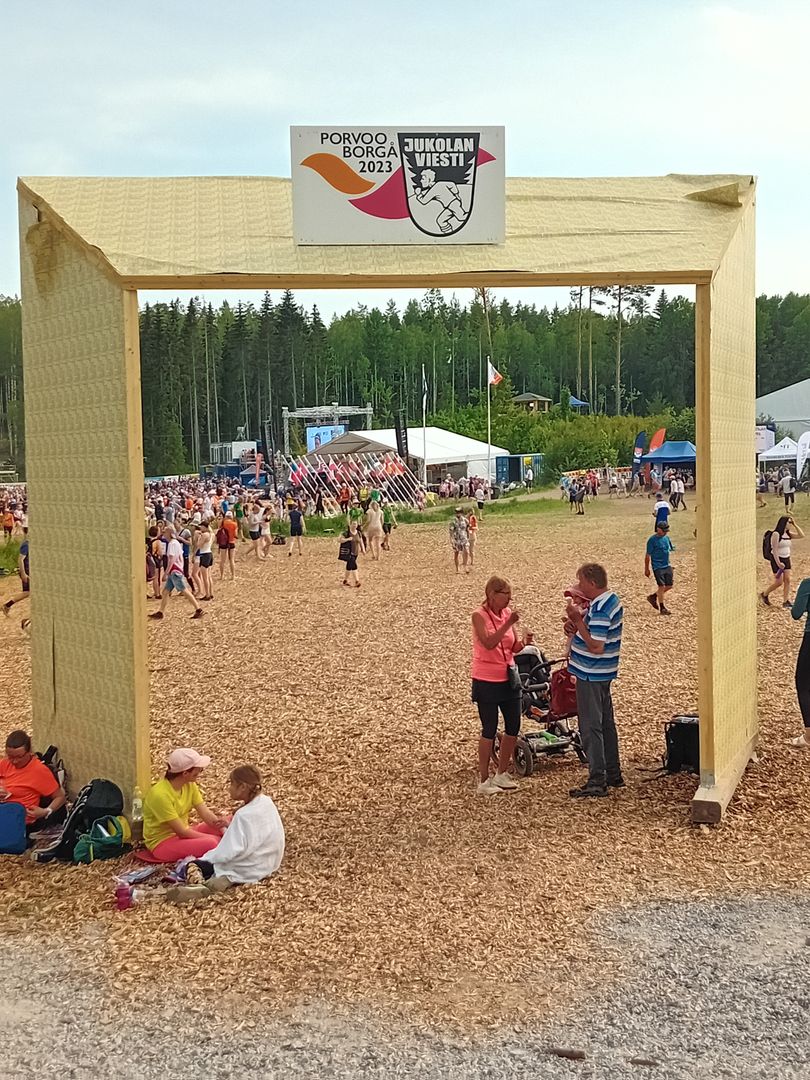 Kuva Jukolan viestin portista, taustalla hiekkakenttä ja ihmisiä.