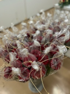 Punaisia ruusuja muovikääreissä.
