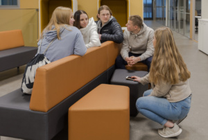 Nuoria istumassa sohvaryhmässä