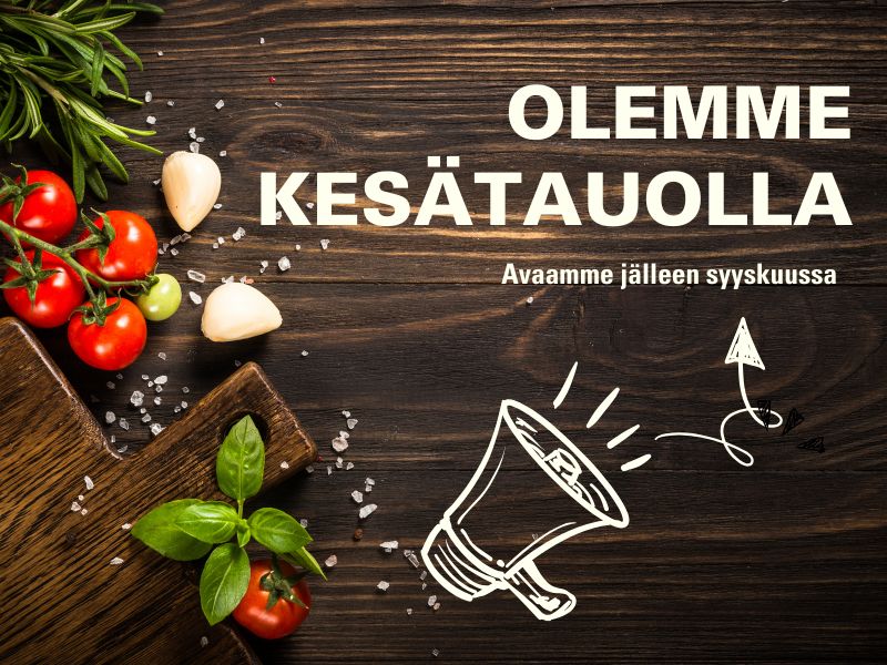 Ravintolateemainen kesäilmoitus tummalla puupöydällä. Kuvassa tomaatteja, valkosipulia, basilikaa ja leikkuulauta. Teksti: “Olemme kesätauolla – Avaamme jälleen syyskuussa”.