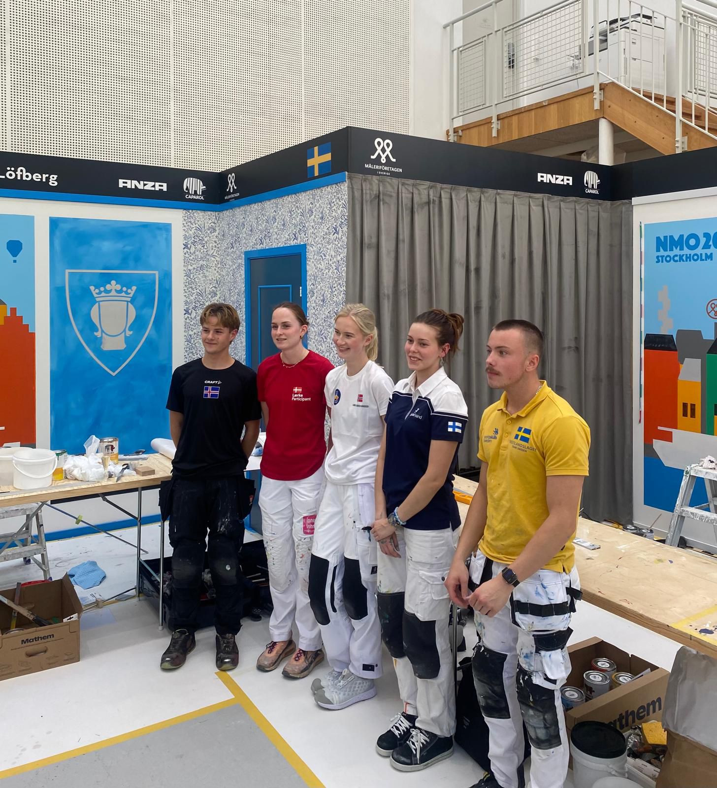 Viisi nuorta yhteiskuvassa taustanaan kilpailumaalaukset.