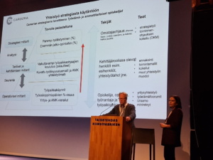 Mies ja nainen pitämässä esitystä oppilaitoksen ja työelämän yhteistyöstä.