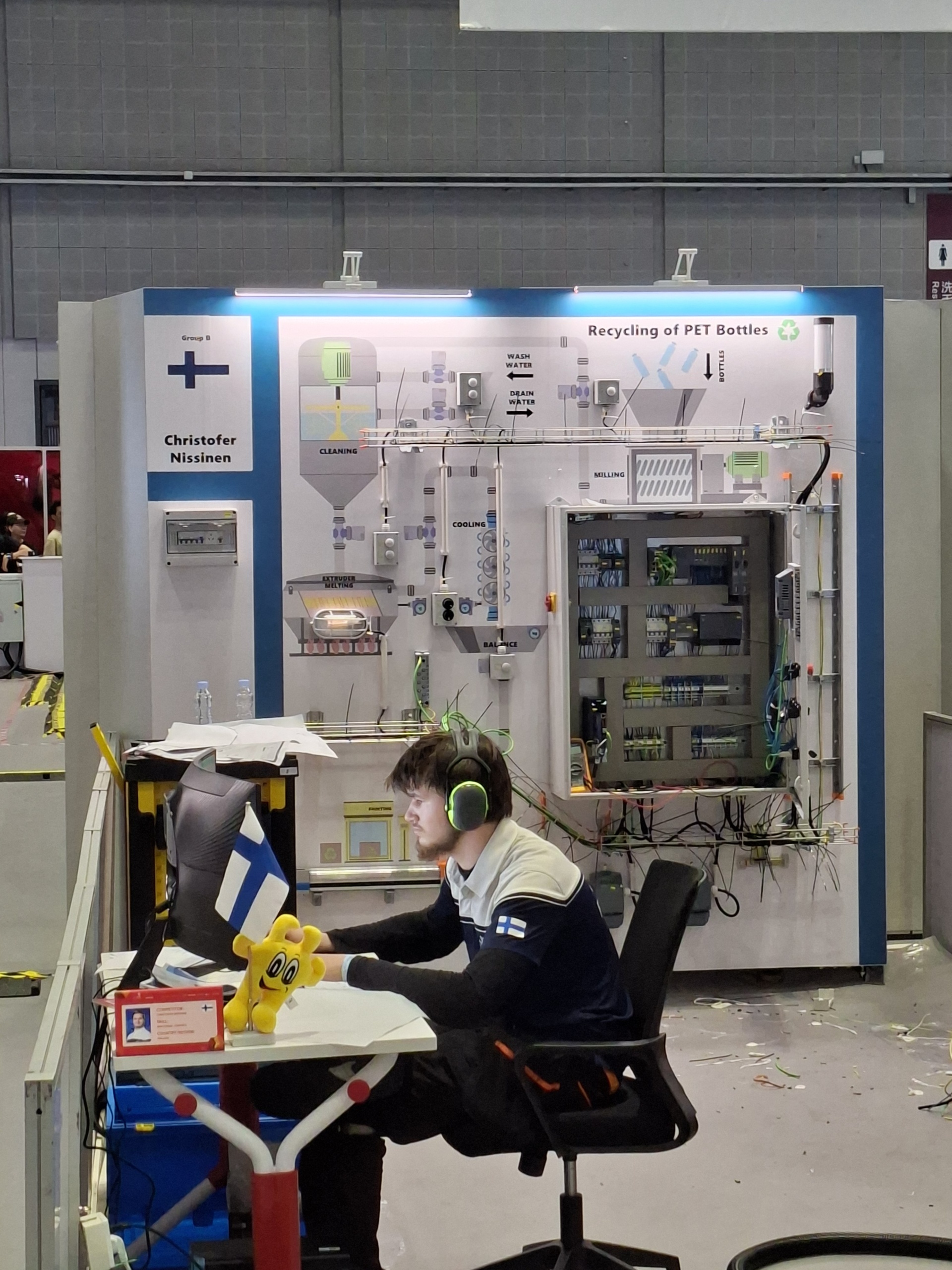 Nuori mies istuu tietokoneruudun äärellä kuulokkeet päässään ja suorittaa automaatioasennuksen tehtävää WorldSkills Shanghai 2026 -kilpailussa.